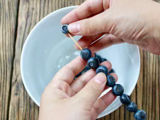 蓝莓Mojito鸡尾酒,蓝莓用牙签固定串成一串，放入杯中即可