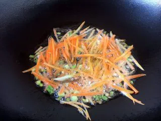 天津特色小吃 蔬菜烩饼,放入胡萝卜丝煸炒几下。