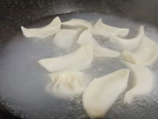 酸辣可口的【酸汤饺子】,等到饺子皮儿变得透明,那么就可以加入少量的清水压上一下,煮好的饺子更加的透亮、而且还十分的好吃。