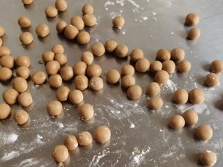 宅家自制珍珠奶茶,将小面块搓成一个个小圆球。上面撒上少许木薯粉防粘。