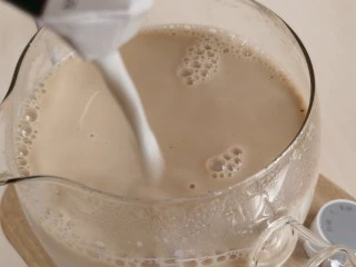 宅家自制珍珠奶茶,将牛奶加入煮好的红茶里。