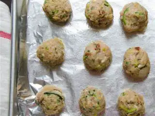 地中海风味火鸡肉丸,用一个汤勺舀取肉馅，用手揉搓做成肉丸，把它放在烤盘上，每个间隔2.5厘米左右。
