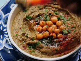 烟熏启波特雷风味鹰嘴豆,把鹰嘴豆泥倒入碗中，依据个人喜好倒一点特级初榨橄榄油 ；撒上欧芹碎 和熏红辣椒粉