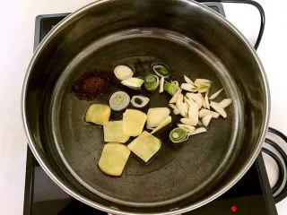 东北风味 密制香辣大肋排,锅里加入1勺大豆色拉油,油烧热后放入姜片,蒜片,葱花和花椒粉