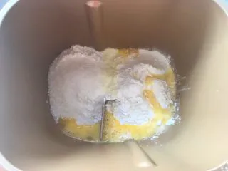 意式红烩牛柳酥,面包桶内加入高筋面粉、低筋面粉、奶粉、全蛋液、砂糖跟酵母