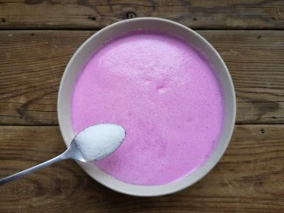 火龙果椰蓉奶冻,将打好的火龙果牛奶倒入大碗中加15克白糖。