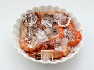 泰式风味酸辣虾,放入容器中，倒入适量冷水和冰块，这样做好的虾口感劲道爽滑好吃。