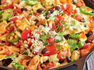 三种芝士布法罗风味鸡肉玉米脆饼,玉米脆饼做好后，在顶部淋上莎莎酱 ，撒上牛油果 和青辣椒圈。