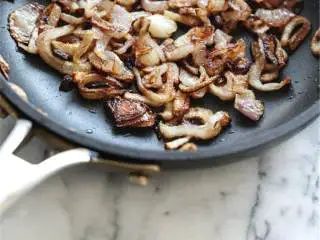 越南风味羽衣甘蓝大虾色拉,取一个中等大小的平底锅,加热融化的椰子油 ,至微微冒烟;小心地加入红葱头 炸制,适时翻动,直到它们变成棕色且香脆;加盐调味。