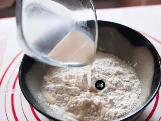 没有烤箱照样做出香浓芝士风味薄底披萨, 然后倒入酵母液体,与面粉混合均匀。根据面粉的吸水性,再多次少量增加水分,直到碗里的面粉完全揉捏成团。此时的面团触感会有些干,表面并不是很光滑,按压时会裂开。没关系,这样就可以等待发酵了。由于每个品牌的面粉吸水性不同,材料表中给出的用水量只能作为参考。最保险的方法,是通过多次少量的方法增加水分,以达到面粉最合适的干湿度。