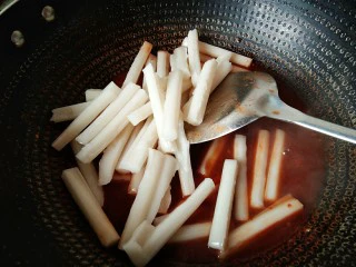 韩式辣炒年糕，炙手可热的小吃,倒入泡好的年糕条。