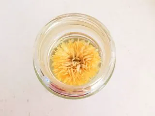 蜜渍柠檬皇菊茶,把开水倒入玻璃杯中