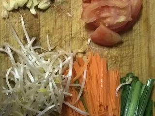 云南风味炒米线,准备好番茄，豆芽，韭菜，胡萝卜丝，姜丝蒜末等