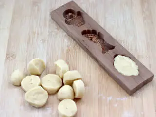 胶东节日小吃~七夕巧果,把剂子放入模具里面,用手摁瓷实。