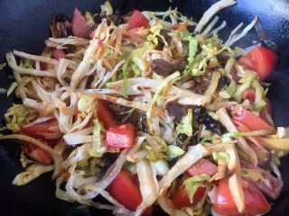 天津特色小吃 蔬菜烩饼,1分钟后打开锅盖儿,把食材翻炒均匀。