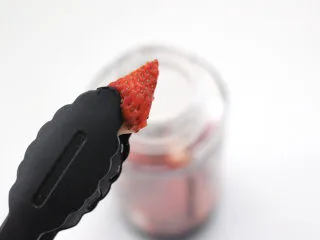 草莓蔓越莓气泡饮,把草莓块放入榨汁杯底。