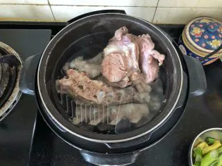 河南小吃-羊肉烩面,4、捞出清冼干净重新放入高压锅中,加入适量的清水。