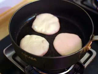 陕西小吃—肉夹馍,锅内倒油,将醒发好的面团放入其间煎至双面金黄。