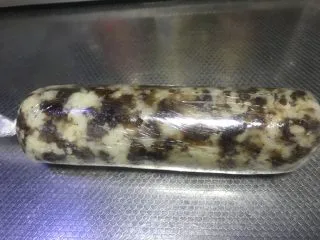 老北京清真小吃-糖卷果,最后将卷好的卷果放到保鲜膜上,两头打结裹紧,晾凉。我一般会将卷好的卷果放入冷藏室冷藏,第二天拿出来继续下一步。