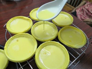 小吃蛋挞，既可作为早餐又是下午茶,将做好的蛋挞液慢慢放到蛋挞盏里去