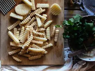 香烤黑松露风味土豆条,把烤架放在烤箱最下层，预热烤箱至230摄氏度；大号的土豆 去皮切成1.25厘米宽的条；剁碎的新鲜欧芹 。