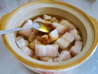 红烧肉,懒办法却更好吃~,在放入五花肉,填上适量的水。 适量就是刚好和肉平齐, 如果不是砂锅这个水量可能就不合适了,在结合实际情况来调整!放入生抽和老抽。