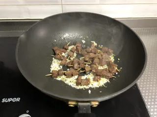 孜然牙签牛肉,倒入牙签牛肉翻炒均匀