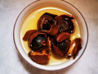 土鸡蛋桂圆枸杞红枣茶,手轻轻撕破外壳,桂圆壳还留在锅里,继续炖煮。