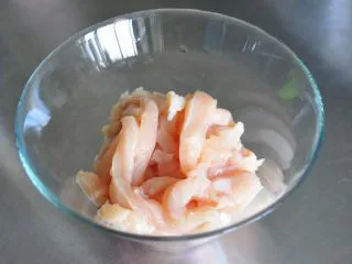 街头小吃自己做---香酥无骨鸡柳,将鸡胸肉斜切成0.5厘米的条。