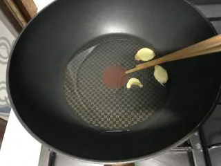 家常小炒韭菜香干,用筷子把炸过的姜片捡出来。