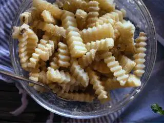 香烤黑松露风味土豆条,大碗中混合玉米淀粉 、黑松露油 、盐 和玉米粉 ；加入土豆条，轻轻搅拌确保土豆条均匀裹上调味料。