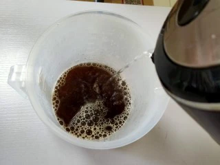 在家也可以制作奶茶,红茶茶叶和开水倒在一个量杯里，盖上盖子。
