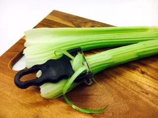 #感恩节食谱# 西芹百合炒腰果,西芹用刮皮刀把老的表皮轻轻的刮一刮。清洗干净。 西芹如果比较嫩就不用刮皮了。