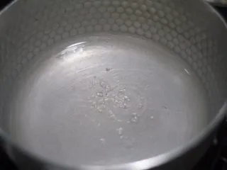 老北京小吃之冰糖葫芦,离火苗3cm摇晃大概五分钟冰糖明显又溶解了不少,剩下的这点就很快溶解了,这个时候水份还没有完全蒸发,不到糖浆的级别,可以改中火摇晃。