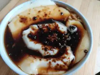 家乡小吃——姜汁红糖豆花,浇上红糖姜汁水,表面再撒上红糖就完成了