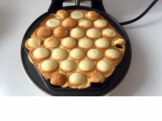 香港名小吃鸡蛋仔,最后记得翻面再烤半分钟的样子,使两面上色情况一样