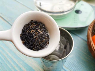 自制高颜值低卡水果茶,茶壶中倒入热水，将红茶放入养生壶中。