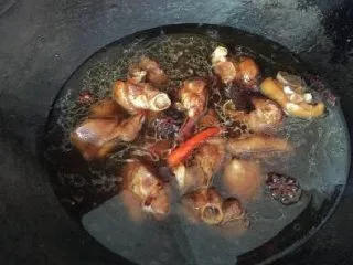 家常菜焖猪脚,此时的猪脚已经明显上色了,马上加入一定的水,要没过猪脚为宜,大火烧开