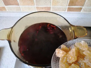 夏季消暑饮品—冰镇酸梅汤,最后加入黄冰糖,关小火煮到冰糖融化。