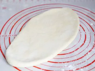 武汉小吃 糯米包油条,松弛后的面团,用擀面杖擀成一厘米厚的面皮。