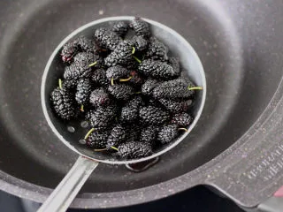 桑葚柠檬冻撞奶,把沥干水分的桑葚放入锅中。