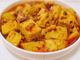 正宗地道的麻婆豆腐,盛入盘中之后，淋上花椒油和辣椒油。