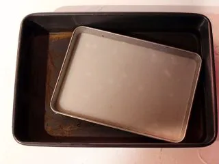 陕西小吃—凉皮,凉皮呈透明状起些小白泡就表明熟透了,取出放入事先准备好的装了凉水的深烤盘中浸泡五分钟。