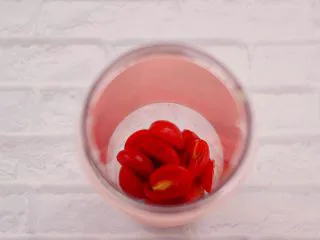 火龙果小番茄蜂蜜果汁,先把果汁杯冲洗干净后，把切片的小番茄放入杯中。