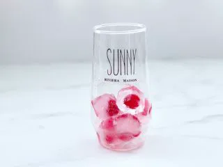 橘子蔓越莓蜂蜜冰饮,杯底先加入冰冻好的的一半蔓越莓果冰块。