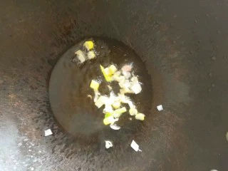 老家传统小吃----韭菜炒肉丝,锅内倒入适量油，放入切好的葱末爆出香味