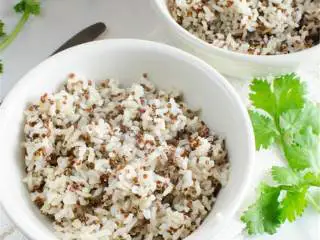 辣墨西哥风味蛋白质碗,根据包装指示在微波炉里加热285克袋装冷冻藜麦和糙米混合 ,分别放在两个碗里。