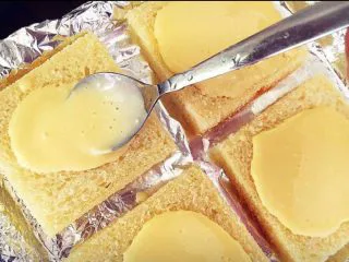 街头流行美食～【岩烧乳酪】,乳酪糊晾凉一会再用小勺浇到吐司片上。