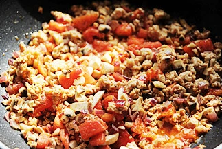 金灿香滑风味十足的异国料理【牧羊人派】,加入番茄继续炒，炒制番茄软烂加入综合干香草、黑胡椒碎、盐和糖；