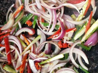 香辣下饭菜～客家小炒鱼干,锅中再放一点油，放葱，辣椒干，小米辣煸炒，再倒入洋葱和青椒(红椒)丝翻炒。